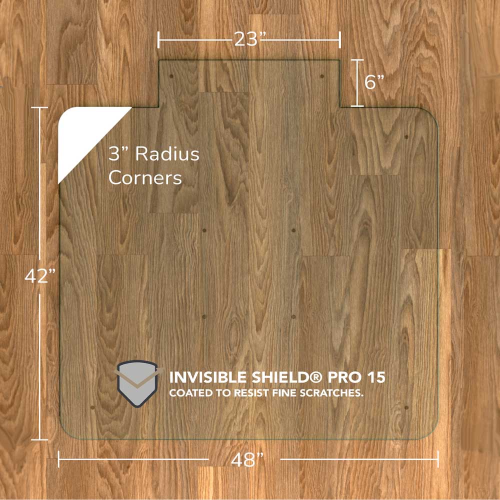 #glass clarity_chiaro (standard clear) alt="A rectangular "chiaro" glass chair mat with dimensions 48 inches by 42 inches, featuring a 23-inch wide top section and 6-inch extension, and 3-inch radius corners. The mat is labeled with "INVISIBLE SHIELD® PRO 15 COATED TO RESIST FINE SCRATCHES." and is placed on a wooden floor."