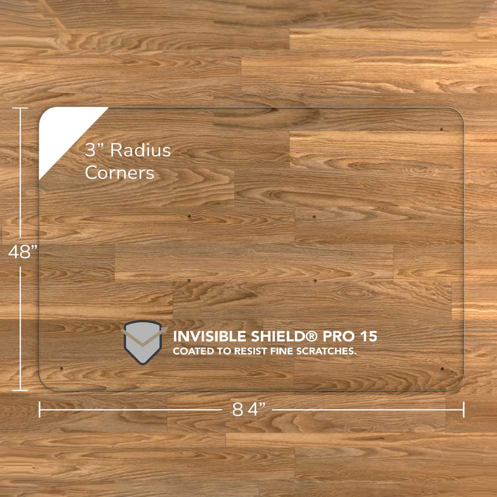 A rectangular luminoso glass chair mat with dimensions of 84 inches by 48 inches, featuring 3-inch radius corners. The mat is labeled with "INVISIBLE SHIELD® PRO 15 COATED TO RESIST FINE SCRATCHES." and is placed on a wooden floor. #Size_48x84#Glass_Clarity_Luminoso