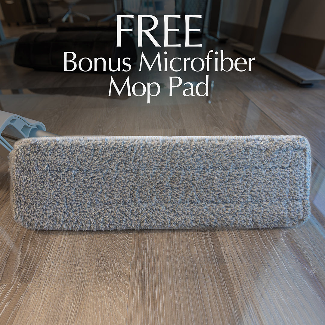 #option_mod mop alt="A grey microfiber mop pad is displayed on a wooden floor. The text above the pad reads: 'FREE Bonus Microfiber Mop Pad.' The background shows part of an office or home environment with furniture and large windows."