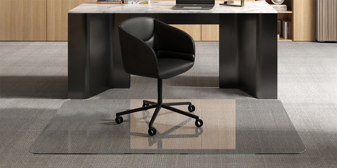 Black office chair on a XL Large Glass Chair Mat in front of a modern marble-topped desk with office items, set in a contemporary office with light wooden cabinetry.