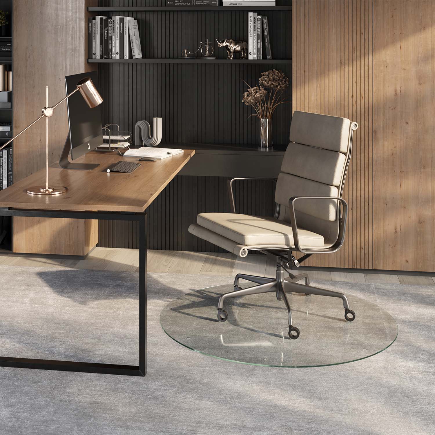 #glass clarity_chiaro (standard clear) alt="A modern home office setup featuring a wooden desk with a computer, lamp, and office supplies. A light-colored ergonomic office chair is positioned on a 48" round "chiaro" glass chair mat placed over a light gray rug. The background includes a wooden panel wall and a shelving unit with books and decorative items."