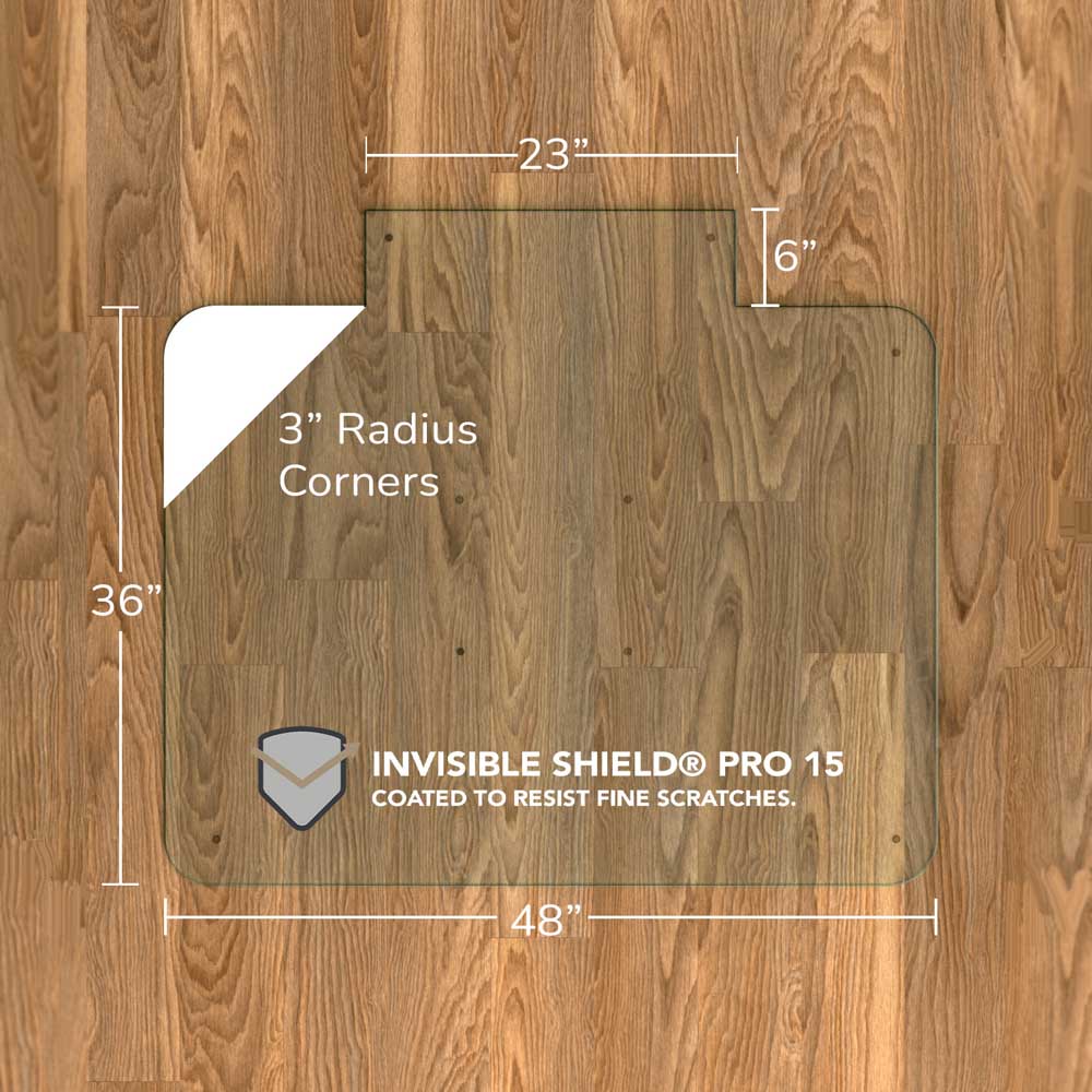 #glass clarity_chiaro (standard clear) alt="A rectangular "chiaro" glass chair mat with dimensions 48 inches by 36 inches, featuring a 23-inch wide top section and 6-inch extension, and 3-inch radius corners. The mat is labeled with "INVISIBLE SHIELD® PRO 15 COATED TO RESIST FINE SCRATCHES." and is placed on a wooden floor."