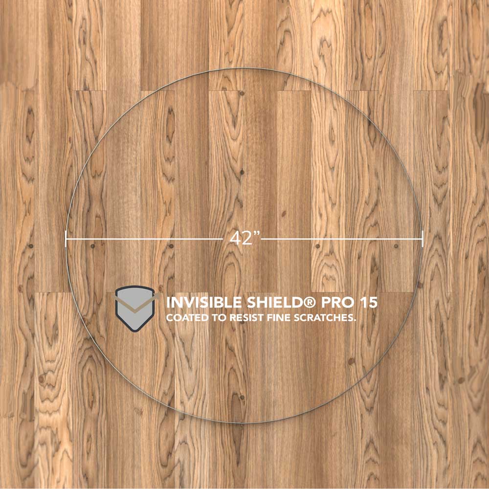 #glass clarity_luminoso (low-iron ultra clear) alt="A round "luminoso" glass chair mat with a diameter of 42 inches, placed on a wooden floor. The mat is labeled with "INVISIBLE SHIELD® PRO 15 COATED TO RESIST FINE SCRATCHES."
