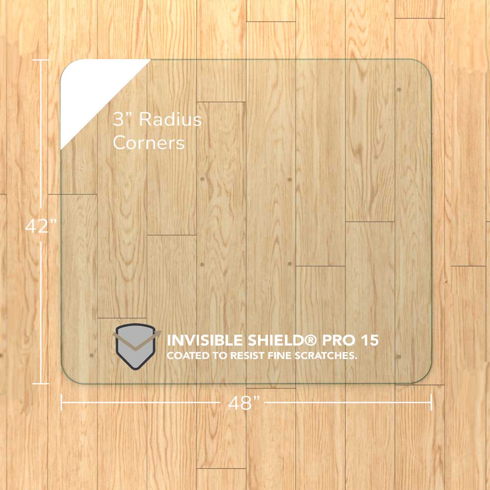 #glass clarity_chiaro (standard clear) alt="A square "chiaro" glass chair mat with dimensions of 42 inches by 48 inches, featuring 3-inch radius corners. The mat is labeled with "INVISIBLE SHIELD® PRO 15 COATED TO RESIST FINE SCRATCHES." placed on a wooden floor."