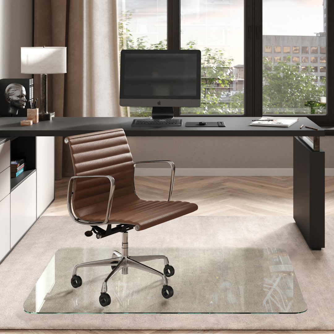 #glass clarity_chiaro (standard clear) alt="Modern home office with a black desk, computer. A brown leather chair on a 46" x 60" "chiaro" glass chair mat on a light rug."
