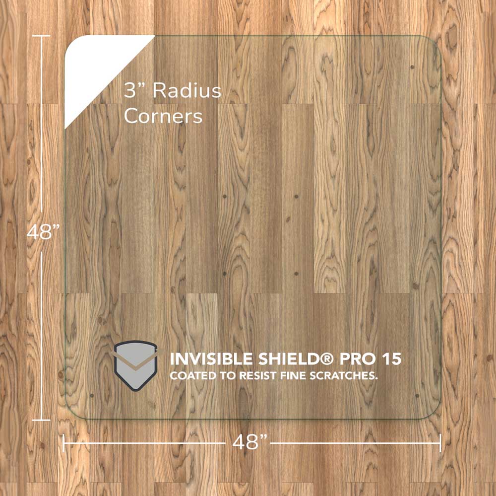 #glass clarity_chiaro (standard clear) alt="A square "chiaro" glass chair mat with dimensions of 48 inches by 48 inches, featuring 3-inch radius corners. The mat is labeled with "INVISIBLE SHIELD® PRO 15 COATED TO RESIST FINE SCRATCHES." placed on a wooden floor."
