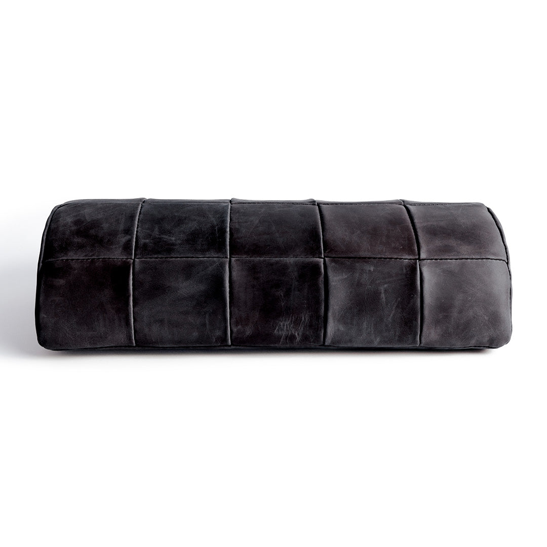 #color_charcoal alt="A black, quilted leather foot rest photographed against a white background. The foot rest has a rectangular shape with a stitched pattern creating a quilted effect."
