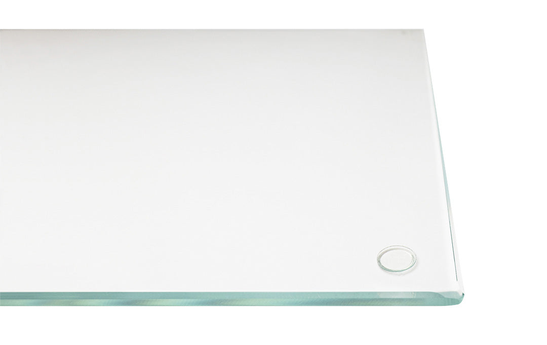 Close-up of a corner of a clear glass "DeskGuard" desk blotter, with a "Stabil-a-dot" visible near one edge. The glass edge is very light in color. The background is white, emphasizing the transparency of the glass.