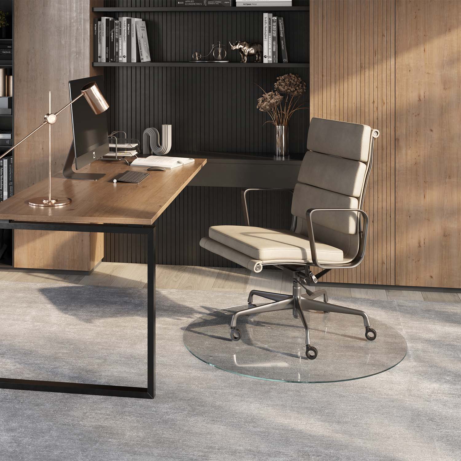 #glass clarity_luminoso (low-iron ultra clear) alt="A modern home office setup featuring a wooden desk with a computer, lamp, and office supplies. A light-colored ergonomic office chair is positioned on a 42" round "luminoso" glass chair mat placed over a light gray rug. The background includes a wooden panel wall and a shelving unit with books and decorative items."
