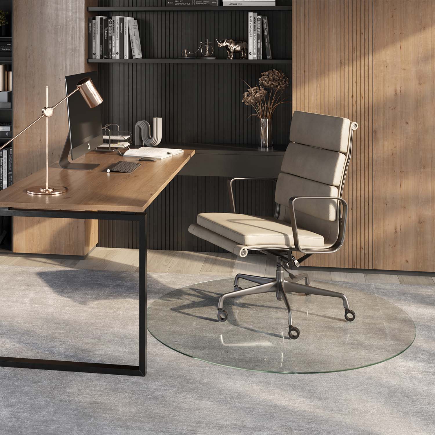 #glass clarity_chiaro (standard clear) alt="A modern home office setup featuring a wooden desk with a computer, lamp, and office supplies. A light-colored ergonomic office chair is positioned on a 54" round "chiaro" glass chair mat placed over a light gray rug. The background includes a wooden panel wall and a shelving unit with books and decorative items."
