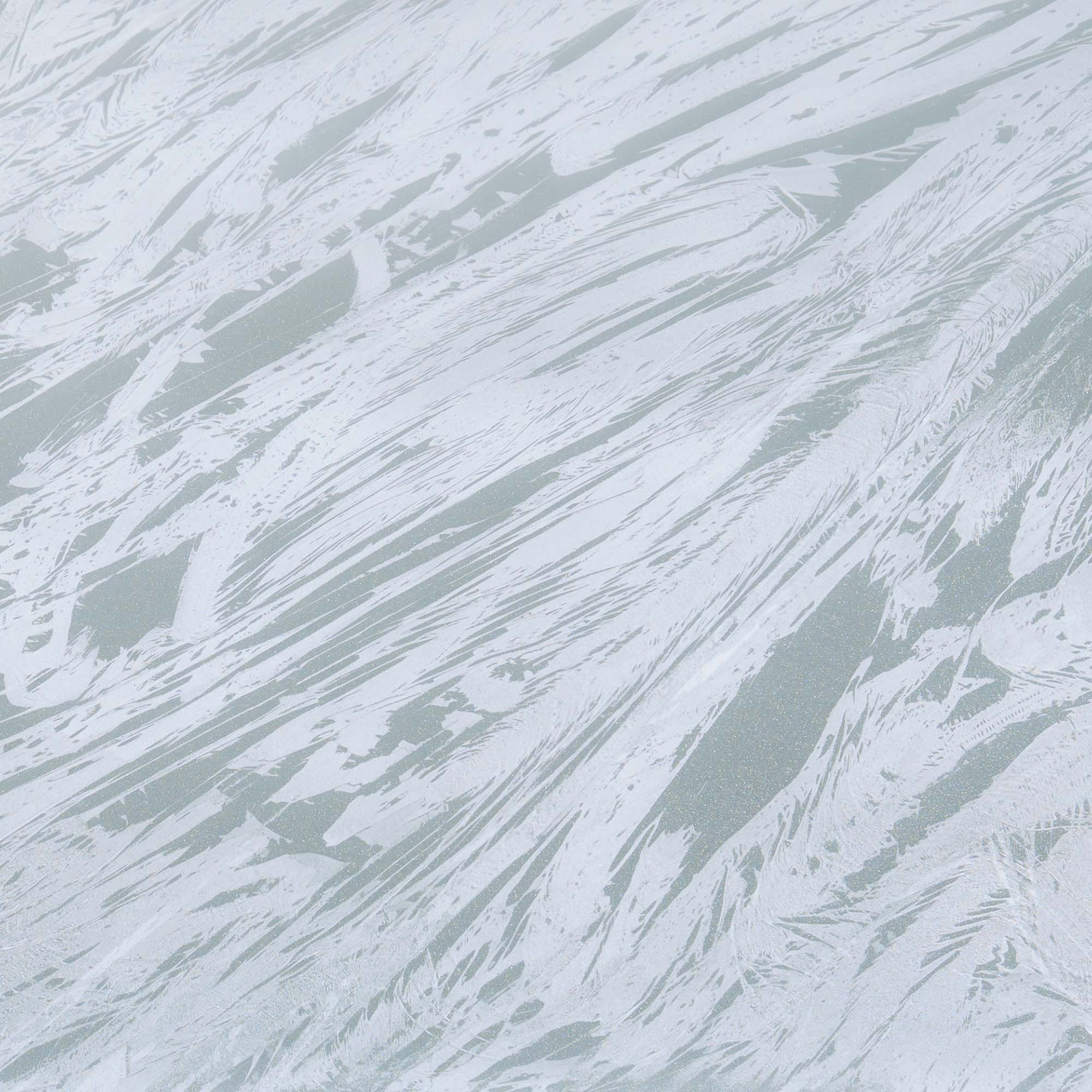 "A close-up view of a textured surface with a pattern resembling flowing water or abstract brush strokes, in shades of light grey and white, creating a dynamic and fluid appearance."
